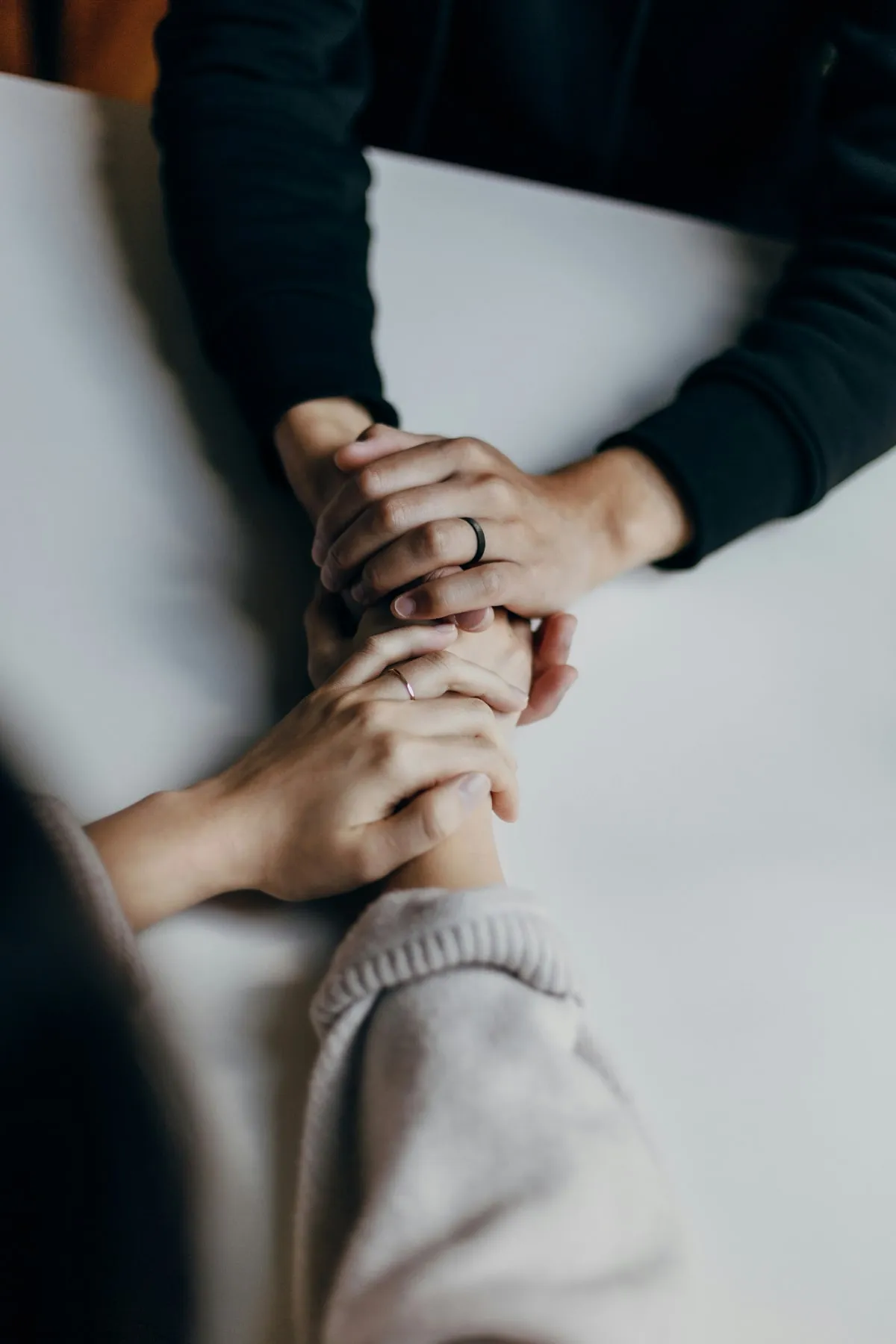 Dos personas tomadas de las manos sobre una mesa